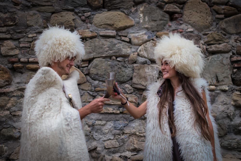 Tourists on local tours in Georgia drinking wine from traditional Georgian wine glasses